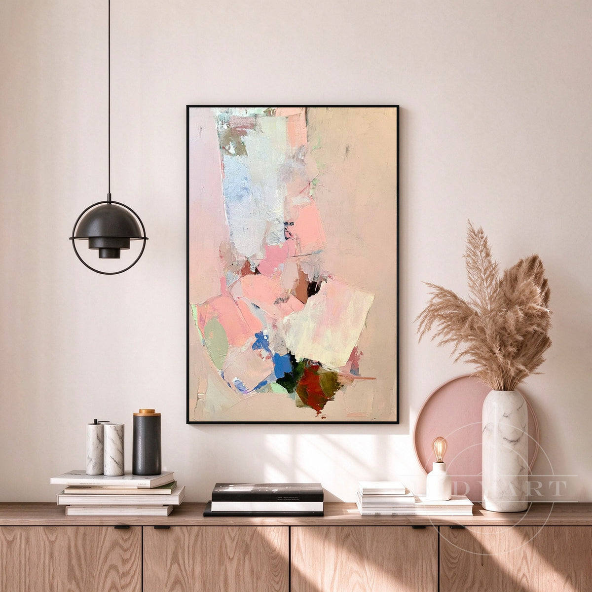 Framed pink and off-white color block canvas art displayed on a minimalist living room feature wall.