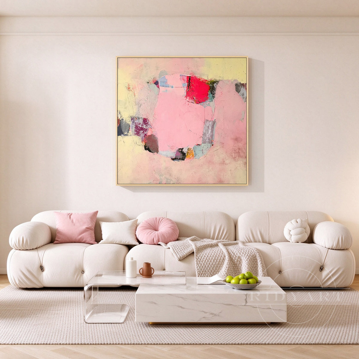 Hand-painted blush pink and cream yellow modern abstract oil painting on canvas above a light sofa in a sunlit living room.