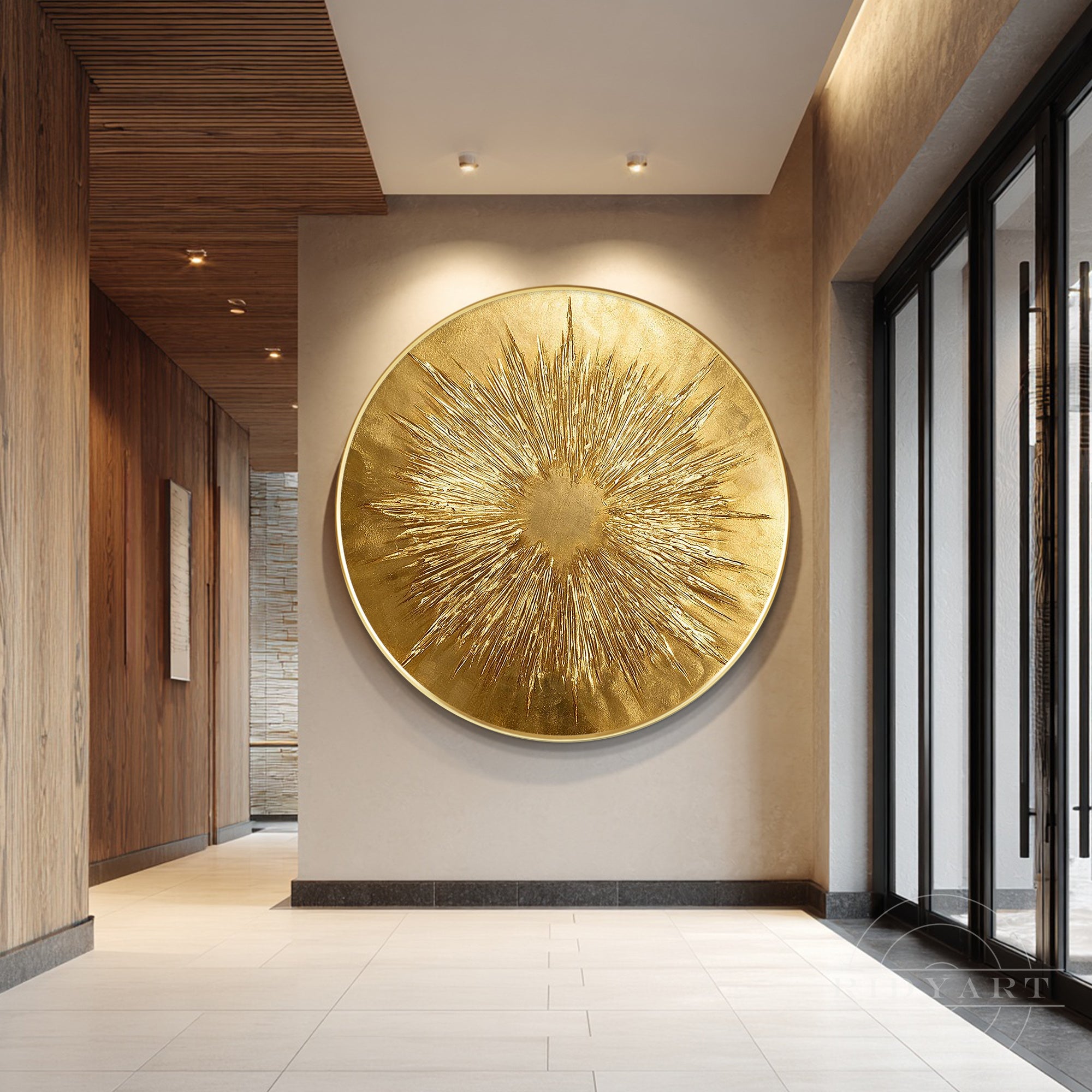Extra large round gold leaf sunburst 3D textured canvas art mounted on a beige wall in a high-ceiling modern hallway.
