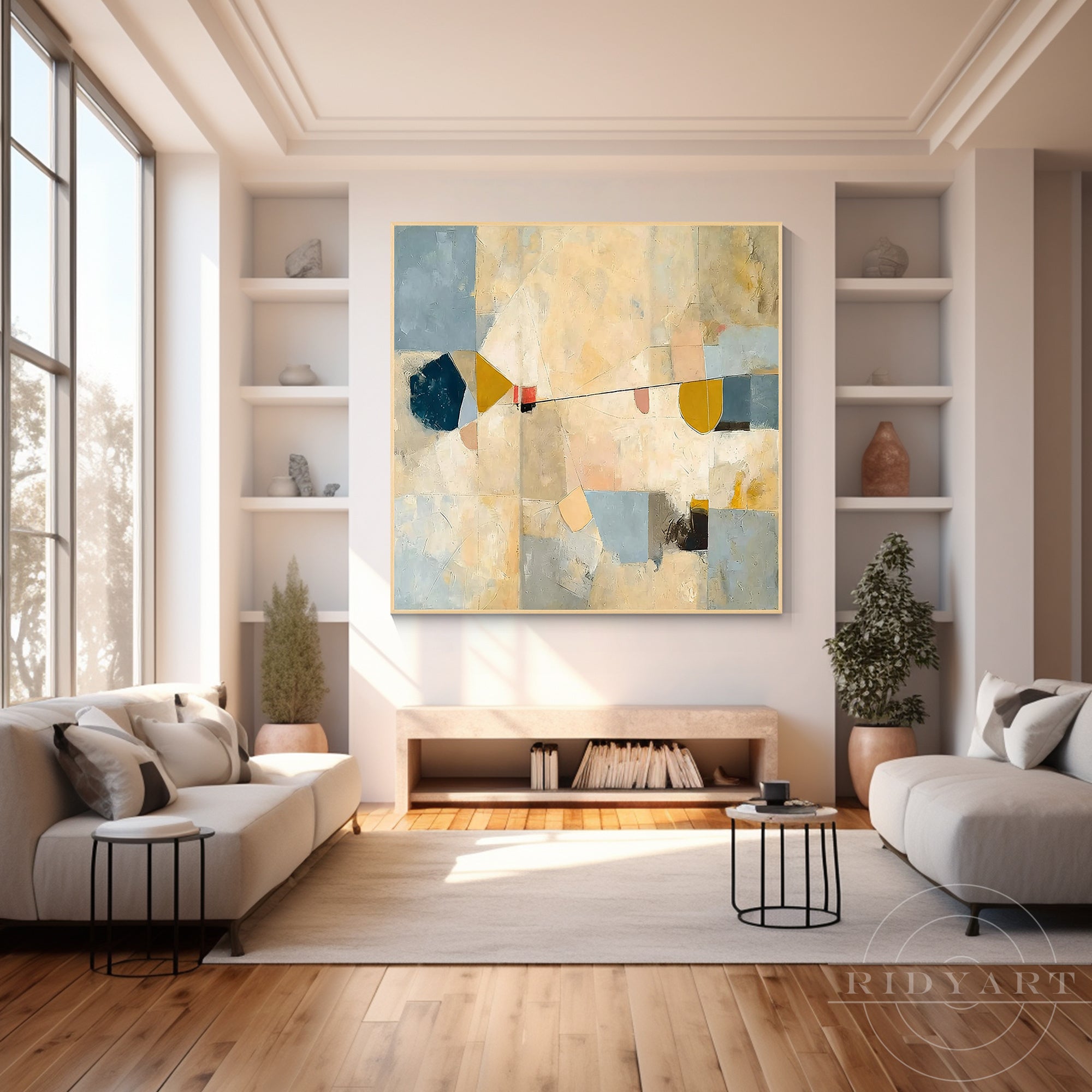 Square geometric abstract wall art displayed on a white wall above a minimalist low credenza and white sofas in a sunlit lounge.