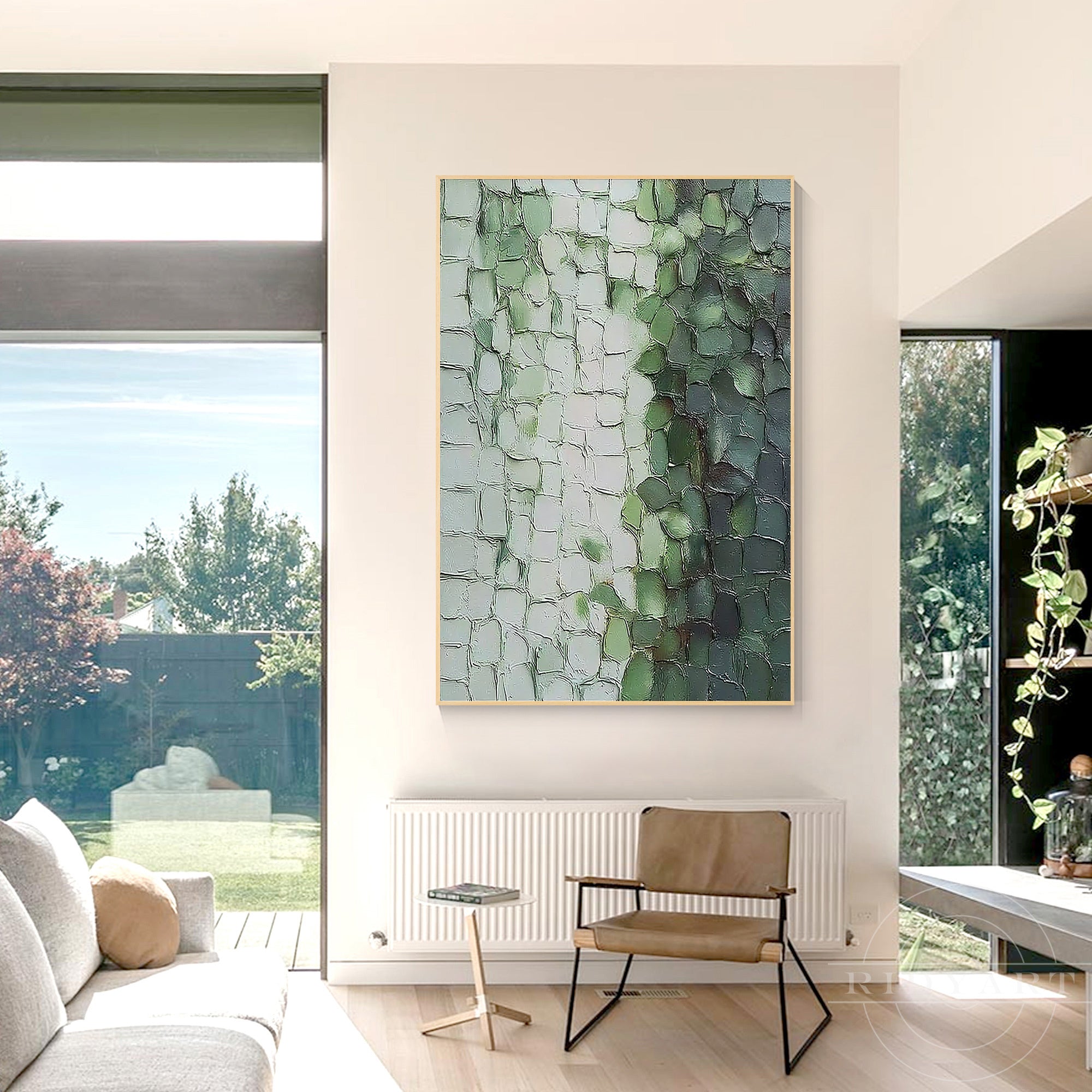 Sage green textured minimalist canvas art hanging in a bright, sunlit modern lounge near floor-to-ceiling windows.