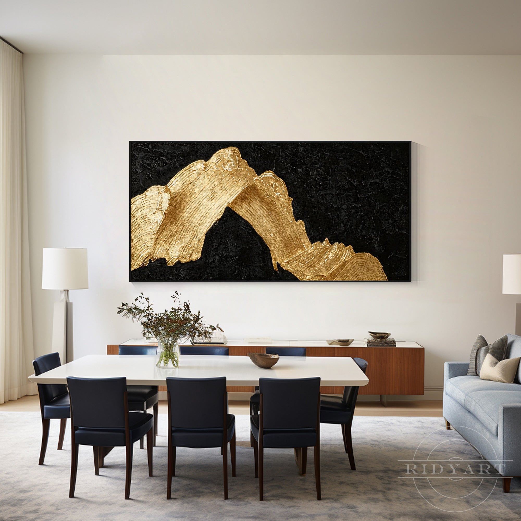 Black and gold abstract mountain wall art hanging in a modern open-concept dining room with dark navy chairs.