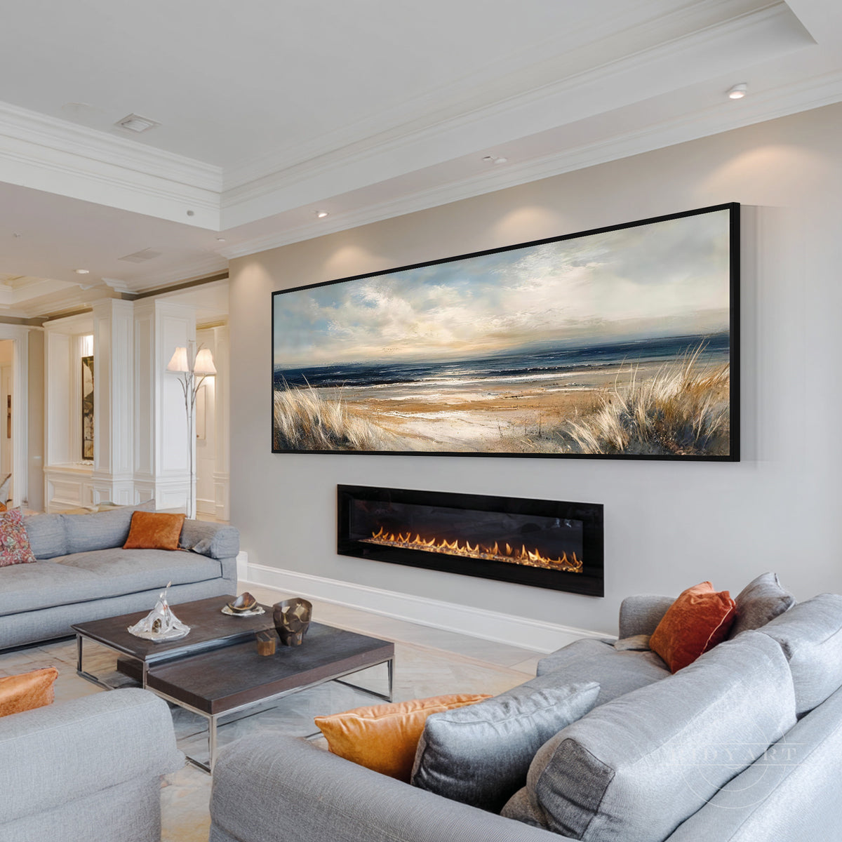 Horizontal coastal wall art displayed above a neutral sofa in a warm modern living room