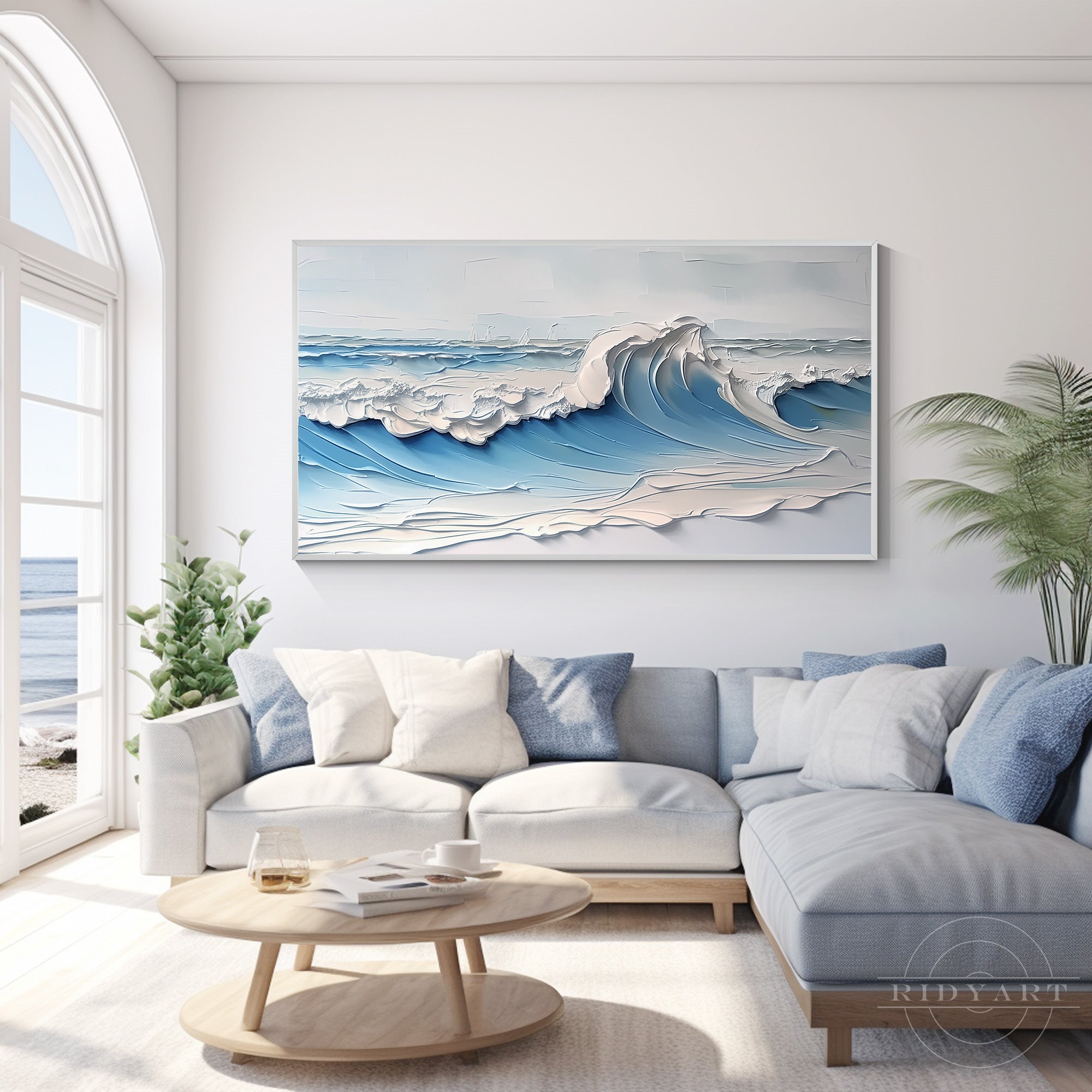 Large-scale textured seascape canvas art featuring a powerful blue wave in motion, styled within a modern, airy interior with potted tropical plants.
