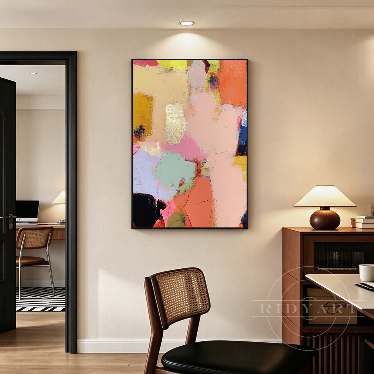 Colorful peach pink and coral abstract wall art with layered shapes and gold frame displayed as a modern living room statement piece.