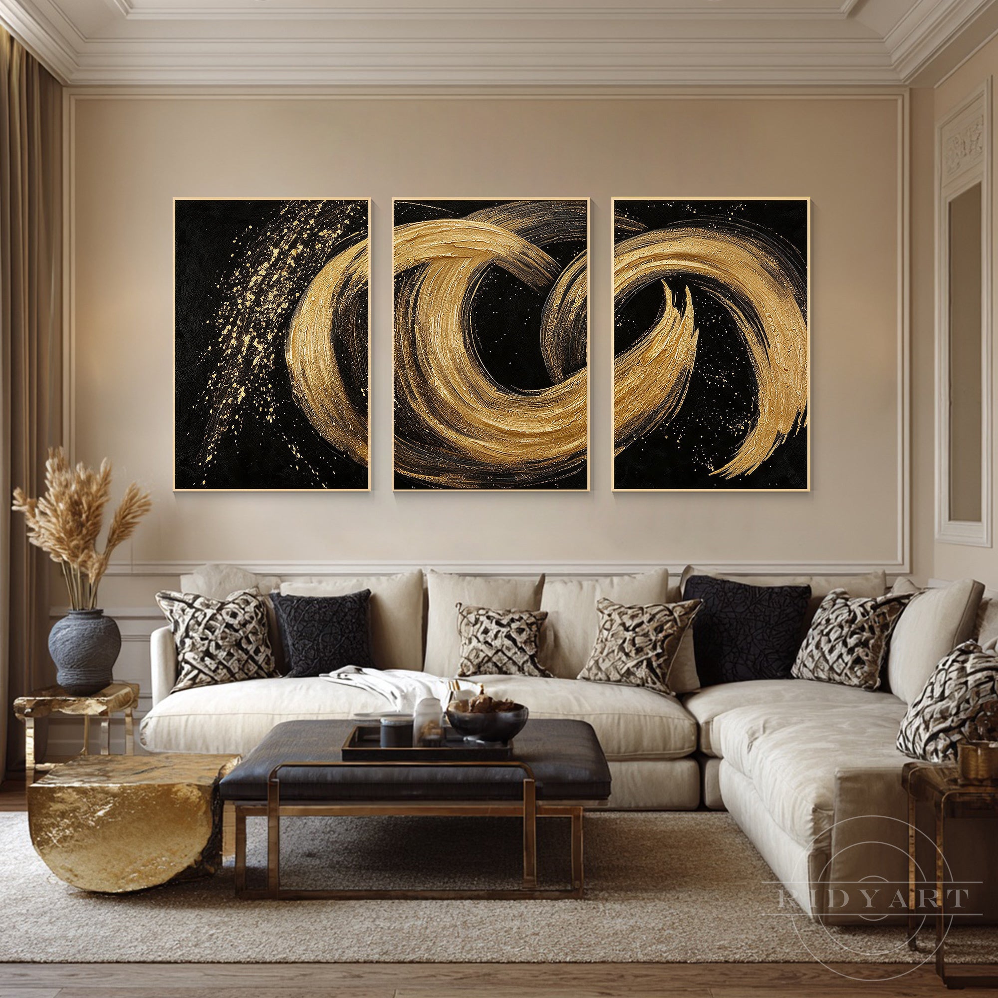 Textured black and gold abstract triptych wall painting set styled in an elegant lounge space above a light beige sectional sofa.