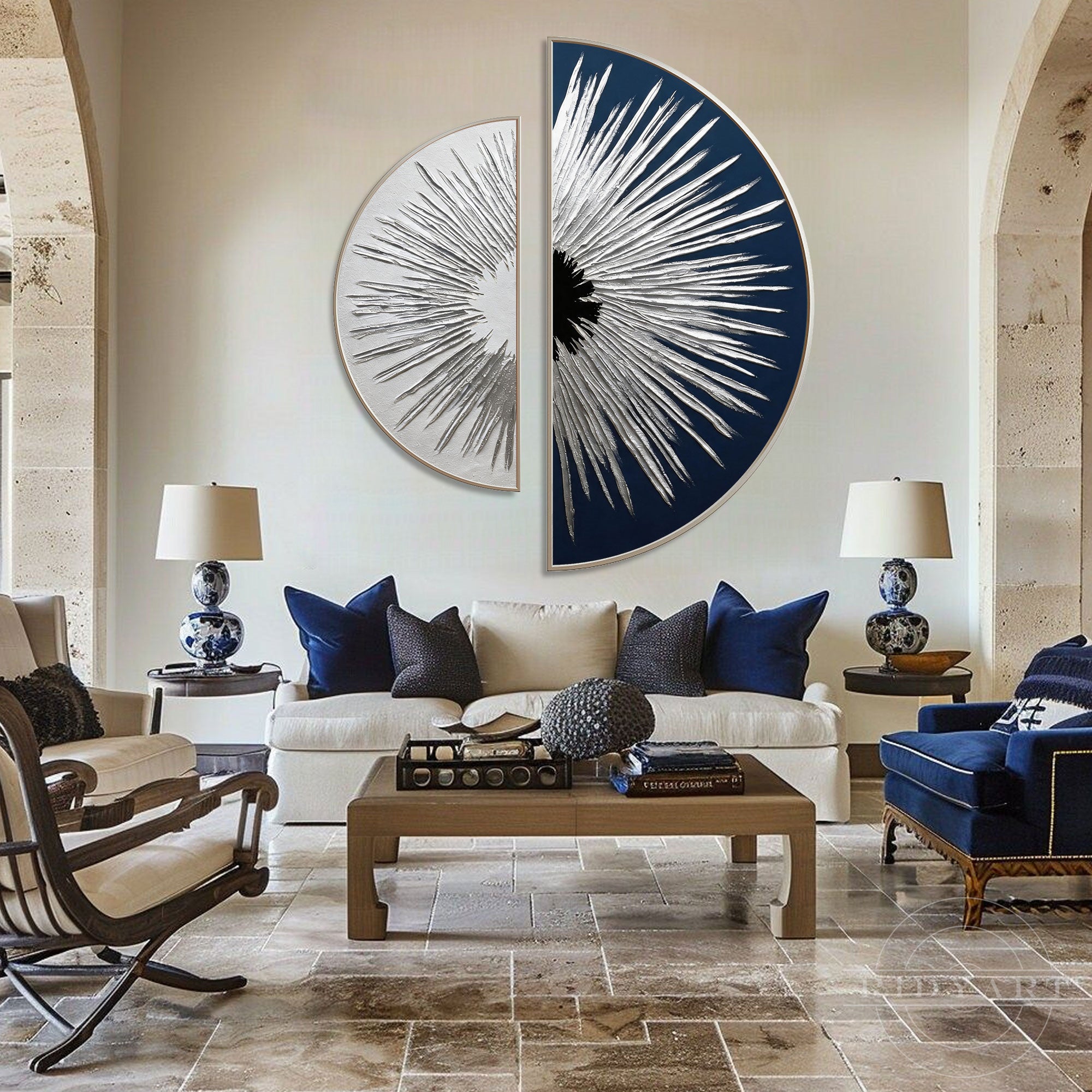 Large silver and navy geometric half-circle statement art hanging above a cream sofa with blue pillows in an upscale living room.
