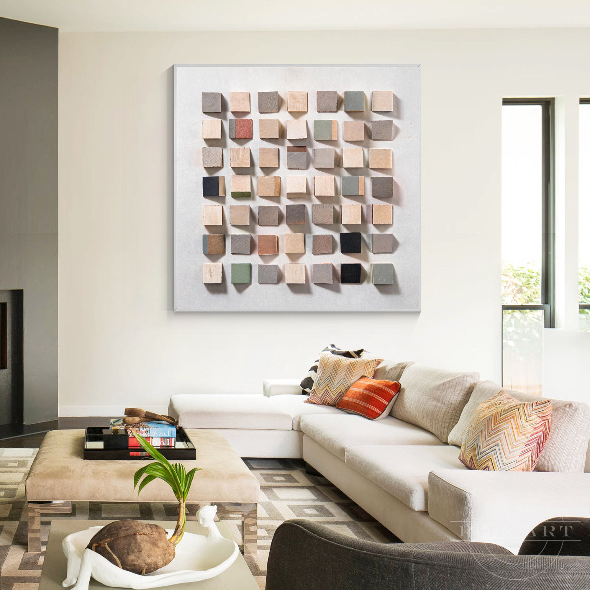 Large 3D geometric wooden block wall art in warm natural wood tones hanging above a beige sofa in a modern bright living room.