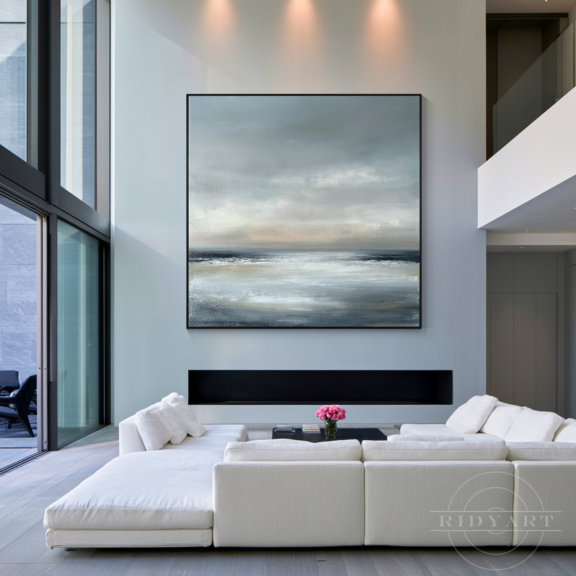 Large square minimalist coastal skyline canvas art framed in black hanging above a contemporary fireplace in a bright, modern open-concept living area.