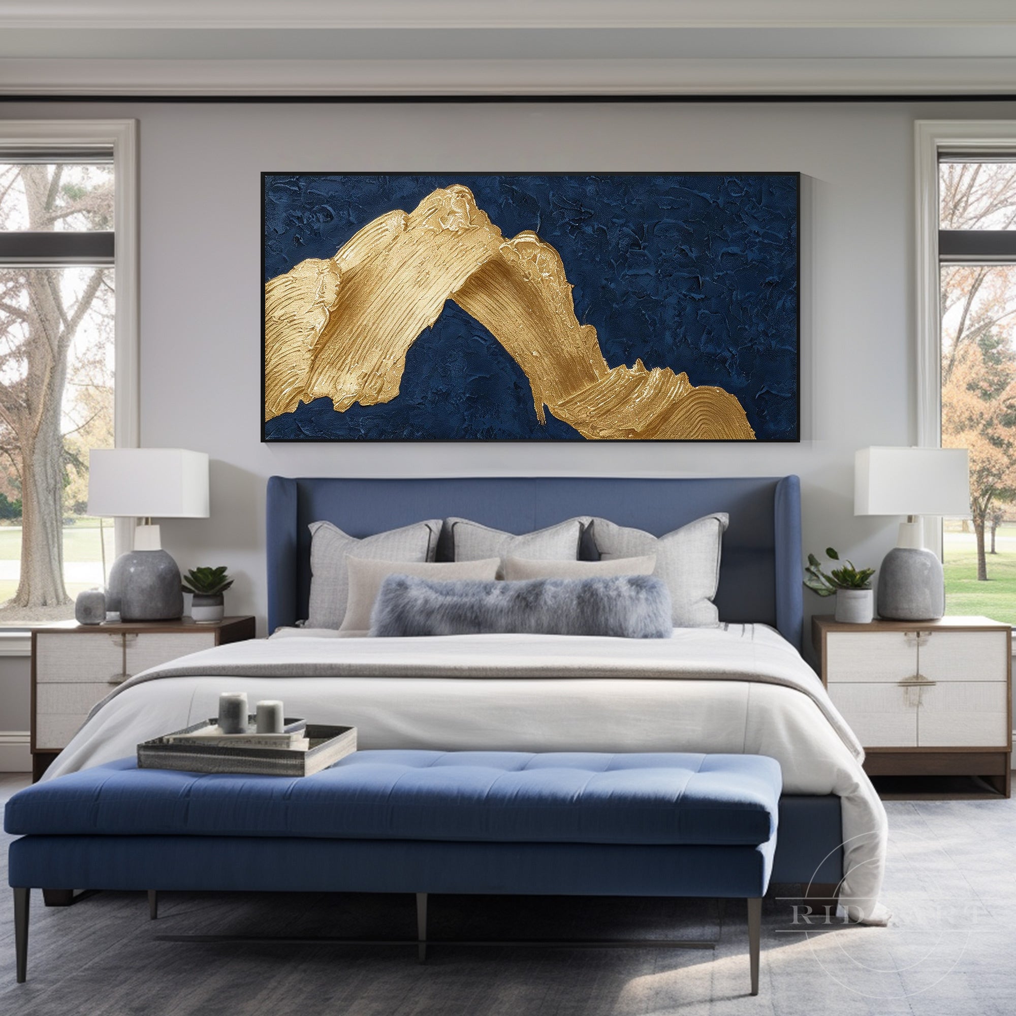 Deep navy blue and gold heavy texture abstract canvas art mounted over a dark blue tufted bed headboard in a contemporary bedroom.